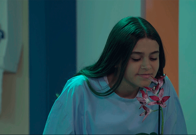 julieta acordada cheirando uma flor